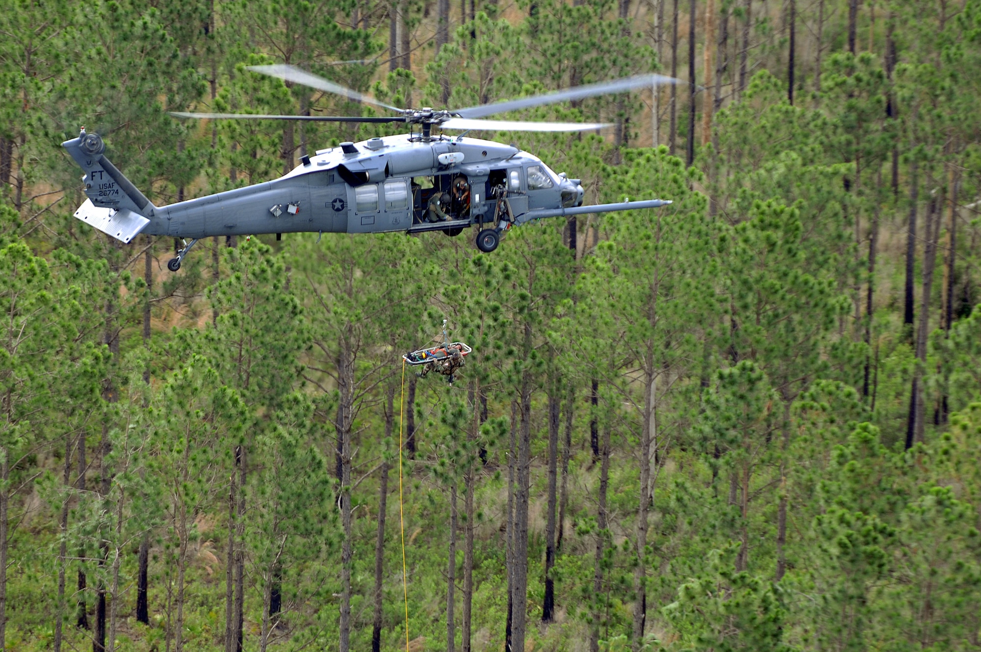 An HH-60G Pave Hawk from the 41st Rescue Squadron, Moody Air Force Base Ga, hoists a patient and para-rescueman, June 27 over Moody's Grand Bay Range. A video production company visited Moody, to film an advertisment for the U.S. Air Force recruiting campaign, "Do Something Amazing." (U.S. Air Force photo by Master Sgt. Scott Reed) 