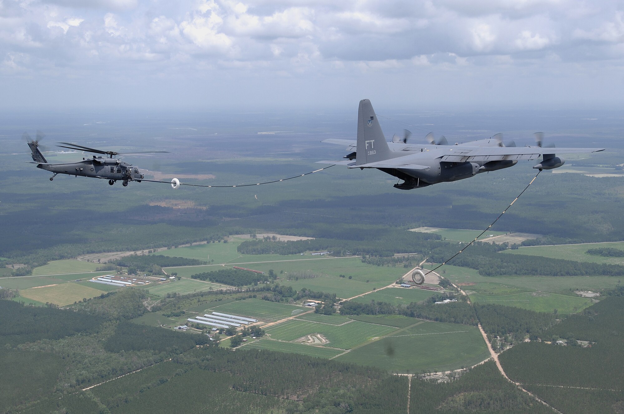 An HC-130P and an HH-60G Pave Hawk perform an aerial refueling mission June 27 in the skies over Georgia. A video production company visited Moody Air Force Base, Ga., to film a spot for the U.S. Air Force recruiting campaign, "Do Something Amazing."  The aircraft and crews are assigned to the 23rd Wing at Moody. (U.S. Air Force photo by Master Sgt. Scott Reed)