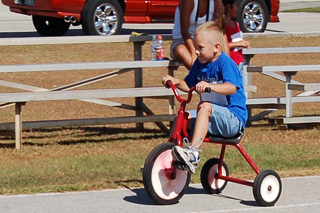 Vinny Gemmiti pedals furiously and wins the tricycle event at the family track day. (U.S. Air Force Photo/Airman 1st Class Carissa Morgan)