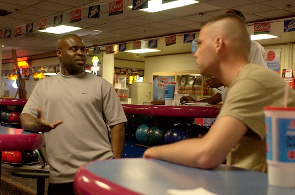 KUNSAN AIR BASE, Republic of Korea --Chief Master Sgt Eric Harmon, 8th Medical Group superintendent, acting Command Chief, provides advice to Senior Airman Steven Doty, Airman Committed to Excellence association president during a bowling match June 23, here.  The match was a result of a challenge between Chief Harmon and Airman Doty.  (U.S. Air Force photo/Staff Sgt Darcie Ibidapo)