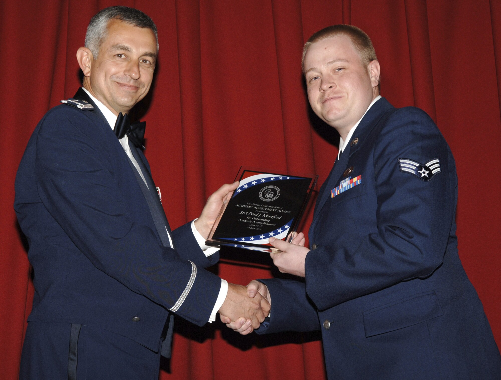 FAIRCHILD AIR FORCE BASE, Wash. -- Col. Roger Watkins, 92nd Air Refueling Wing vice commander, presents Senior Airman Paul Munford with the Airmen Leadership School Academic Achievement Award during the ALS graduation June 28. Airman Munford was also the recipient of a Distinguished Graduate Award. (U.S. Air Force photo/Airman 1st Class Nancy Hooks)