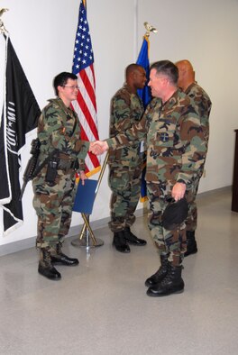Col. Bryan Gallagher (right), 95th Air Base Wing commander, presents two Airmen with their next stripe at the Security Forces Squadron headquarters building Monday. Airmen 1st Class Brooke Garton (left) and Mark Smith (center), 95th SFS security police, were awarded the rank of Senior Airman below the zone. (Photo by Airman Mike Young)