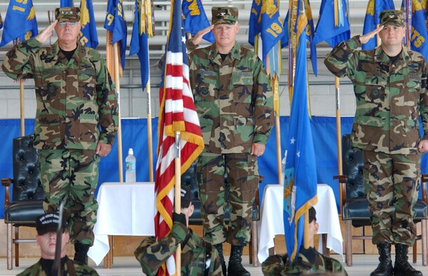 Lt. Gen. Michael Wooley, Air Force Special Operations Command commander, Col. Norm Brozenick Jr., former 1st Special Operations Wing commander, and Col. Brad Webb, new 1st SOW commander, render salutes to the colors during the playing of the National Anthem during the change of command ceremony held Tuesday in Freedom Hangar. (U.S. Air Force photo by Tech. Sgt. Angela Shepherd)