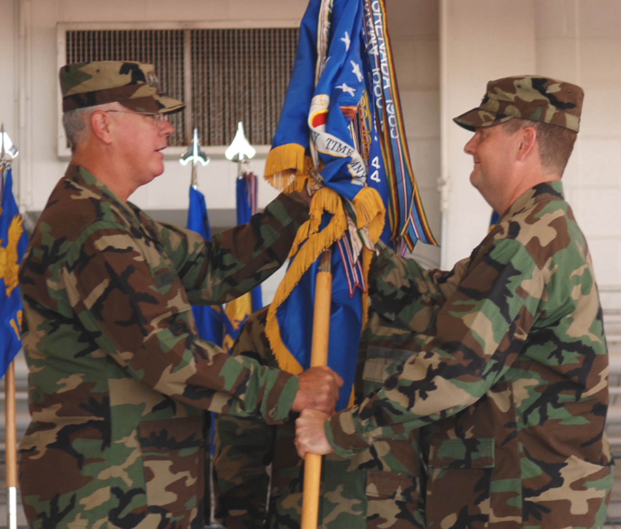 Lt. Gen. Michael Wooley, Air Force Special Operations Command commander, passes the 1st Special Operations Wing guidon to Col. Brad Webb, the new 1st SOW commander, during the change of command ceremony held Tuesday at Freedom Hangar. (U.S. Air Force photo by Senior Airman Andy Kin)