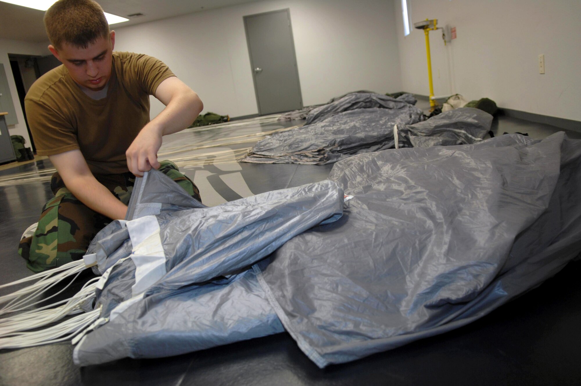 Senior Airman Daniel Danker packs a parachute June 25 at Davis-Monthan Air Force Base, Ariz. Airman Danker is an aircrew flight equipment journeyman assigned to the 563rd Operation Support Squadron where he maintains parachutes for pararescuemen, along with other types of survival equipment. (U.S. Air Force photo/Senior Airman Christina D. Ponte)