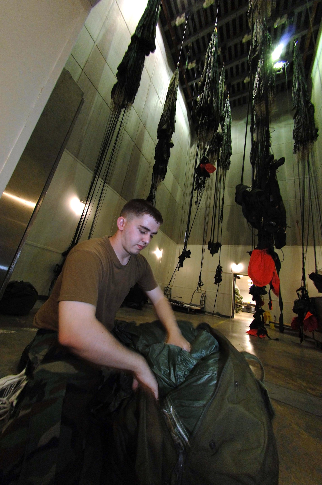 Senior Airman Daniel Danker places a parachute into a bag June 25 at the air-drying facility at Davis-Monthan Air Force Base, Ariz. Airman Danker is an aircrew flight equipment journeyman assigned to the 563rd Operation Support Squadron where he maintains parachutes for pararescuemen, along with other types of survival equipment. (U.S. Air Force photo/Senior Airman Christina D. Ponte)