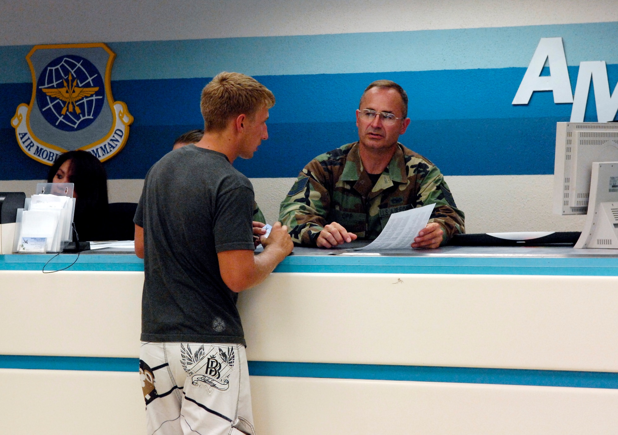 Tech. Sgt. Timothy Opp helps a passenger in the passenger terminal center July 2 at Hickam Air Force Base, Hawaii. Reservists from the 87th Aerial Port Squadron from Wright-Patterson AFB, Ohio, are conducting their two-week duty with the 735th Air Mobility Squadron. (U.S. Air Force photo/Tech. Sgt. Shane A. Cuomo)