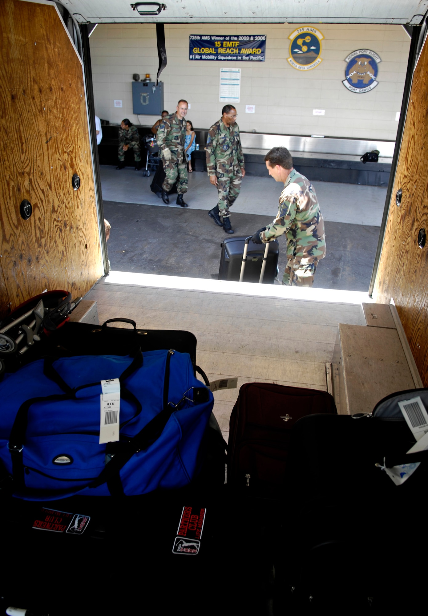 An air transportation specialist loads suitcases on a van July 2 at the passenger terminal center at Hickam Air Force Base, Hawaii. Reservists from the 87th Aerial Port Squadron from Wright-Patterson AFB, Ohio, are conducting their two-week duty with the 735th Air Mobility Squadron. (U.S. Air Force photo/Tech. Sgt. Shane A. Cuomo) 
