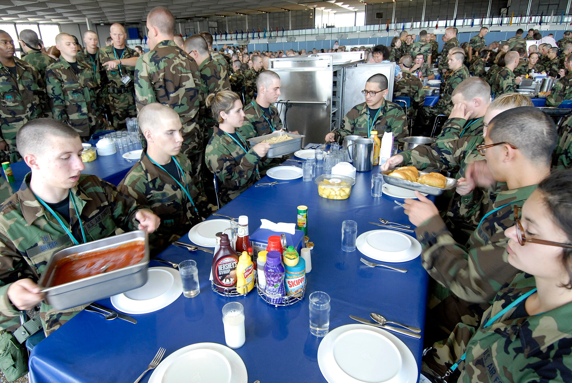 Basic cadet trainees prepare for their first lunch since arriving as the Class of 2011, as infractions are dealt with, and corrected, at surrounding tables June 29 at the U.S. Air Force Academy in Colorado. The cadets are in their first week of training and must not take their eyes off the eagle on their plate as they eat. They are in the first half of basic cadet training, commonly known as "First Beast." (U.S. Air Force photo/Mike Kaplan) 
