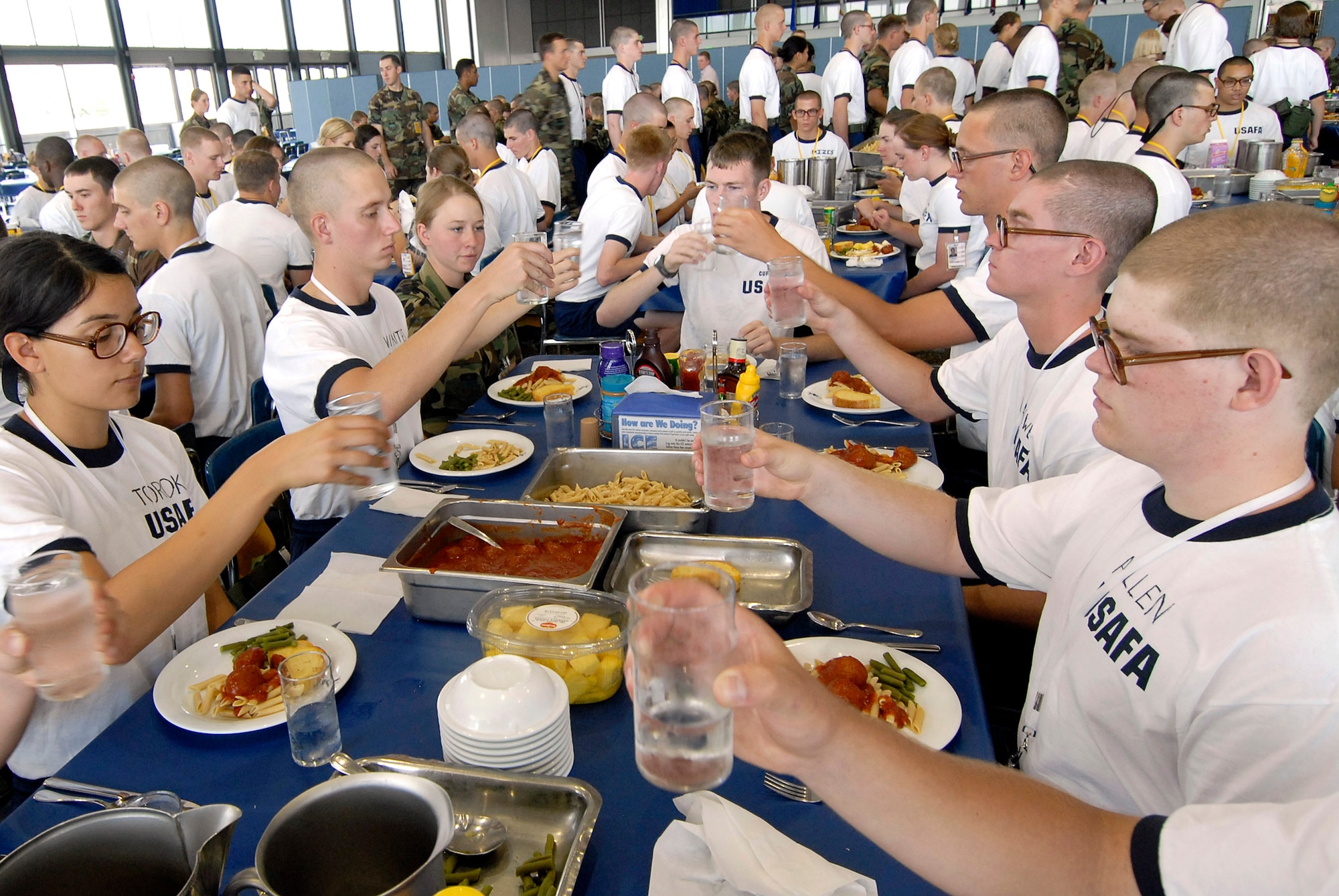 Basic cadet trainees make a toast during their first lunch since arriving as the Class of 2011 June 29 at the U.S. Air Force Academy in Colorado. The cadets are in their first week of training and must not take their eyes off the eagle on their plate as they eat. They are in the first half of basic cadet training, commonly known as "First Beast." (U.S. Air Force photo/Mike Kaplan) 

