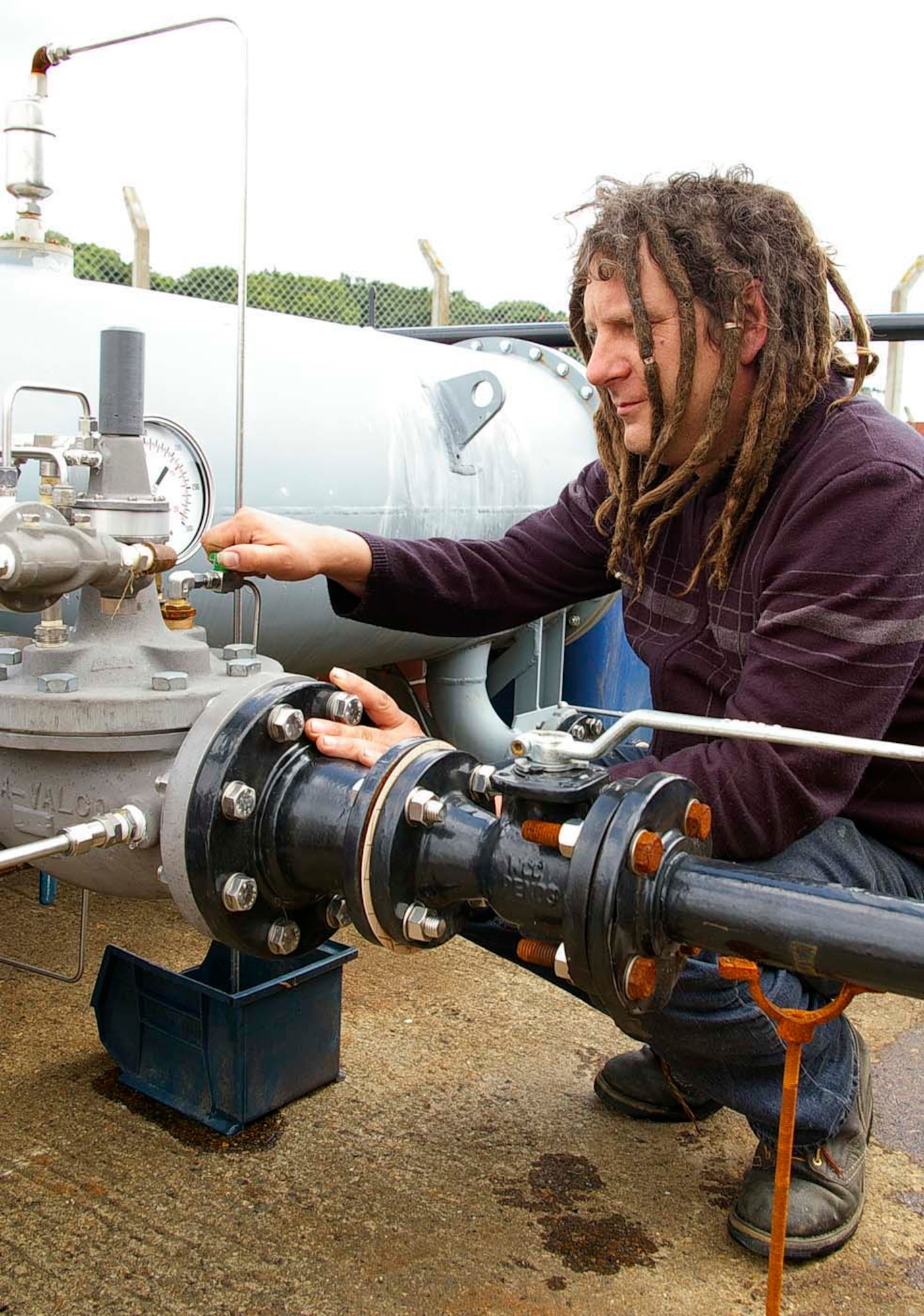 Paul Murfitt, a Ministry of Defence employee in the 100th Civil Engineer Squadron, vents air from the automatic valve on the filter equipment he built to recycle JP-8. The filter can recycle the fuel so it can be made into heating oil. This gives a saving of $4 per gallon ($2 to buy it and $2 to dispose of it) for the U.S. Air Force. (U.S. Air Force photo by Karen Abeyasekere)