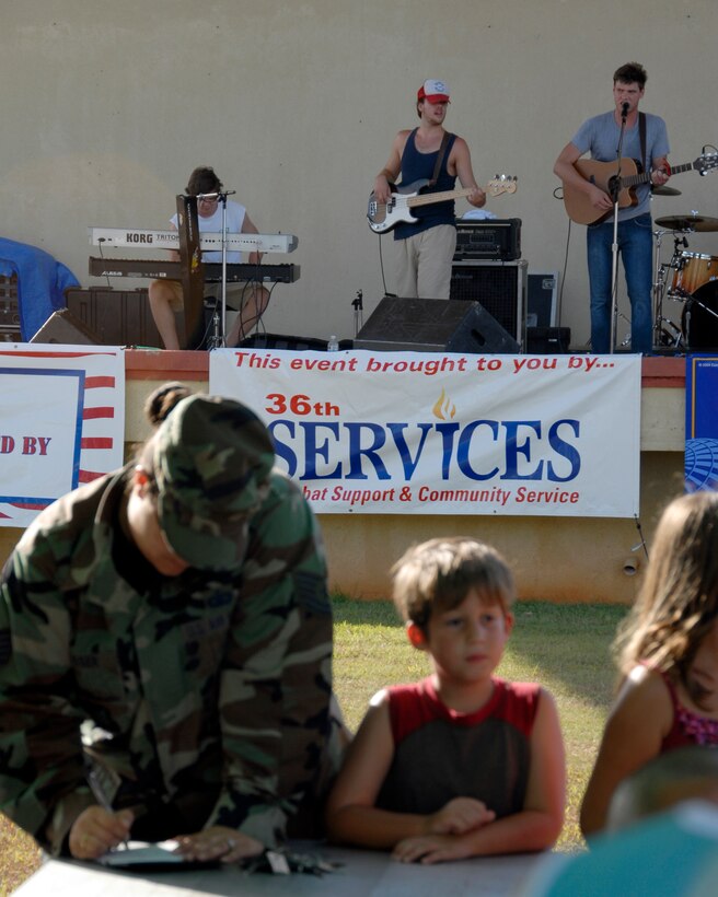Team Andersen members enjoy music from Sons of Bill as they register for prizes during the annual Freedom Fest. (U.S. Air Force Photo by Airman First Class Daniel Owen)