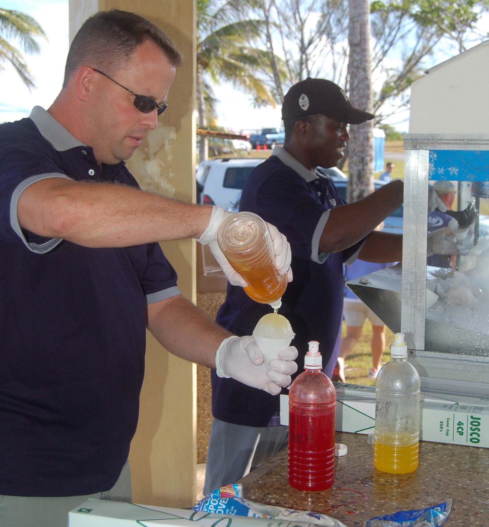 (From left) Master Sgt. Wes Willand and Master Sgt. Fenton Fitzgerald, from the Air Force Sergeant's Association chapter 1560, serve snow cones at Andersen's annual Freedom Fest. (U.S. Air Force Photo/AIrman 1st Class Carissa Morgan)