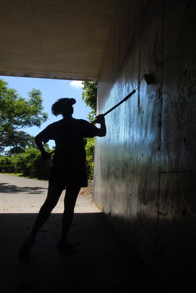 Staff Sgt. Erin Rieffer, 18th Aeromedical Evacuation Squadron, paints a graffiti wall at a park outside of Kadena's Gate 2 as part of a humanitarian and beatification project June 30.  More than 18 people volunteered their time to paint the tunnel which was covered in graffiti.
U.S. Air Force Photo/Senior Airman Jeremy McGuffin