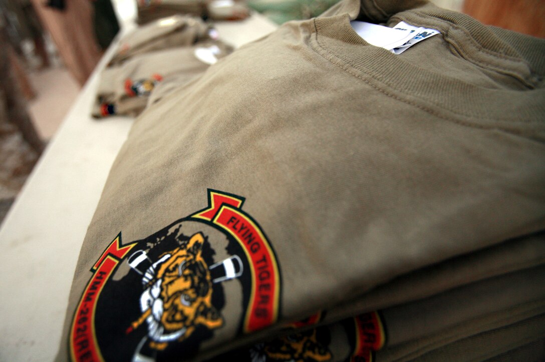 AL TAQADDUM, Iraq (July 4, 2007) ?   A pile of t-shirts sits on a table here July 4.  The ?Flying Tigers? of Marine Medium Helicopter Squadron 262 were presented more than 200 screen printed T-shirts and 500 handwritten letters donated by citizens from Maine, Virginia and Connecticut during a ceremony.