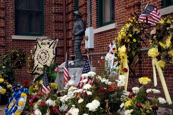 Wreaths of flowers and flags are placed by the local community around the firefighter statue at the Charleston Fire Department to show their support and respect for the nine fallen firefighters that lost their lives June 18.  (U.S. Air Force photo/ Staff Sgt. April Quintanilla)