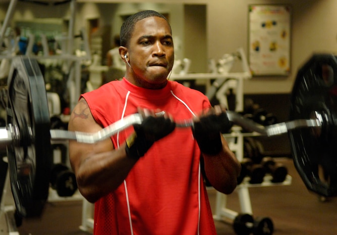 Maurice Johnson, 437th Aerial Port Squadron, works his biceps with the bicep curl using the E-Z-bar.  (U.S. Air Force Photo/Airman 1st Class Nicholas Pilch)