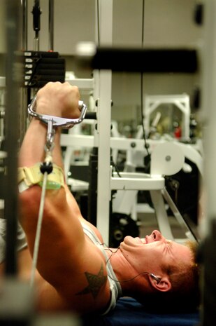 Jeff Mills, assigned to the U.S. Coast Guard Gallatin, works his chest muscles on the flat bench cable fly.  (U.S. Air Force Photo/Airman 1st Class Nicholas Pilch)