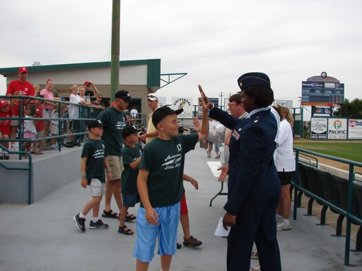 Maj. Rosalyn Walker, 341st Services Squadron commander, high-fives a Malmstrom Little Leaguer before the start of the White Sox Game June 29. (U.S. Air Force photo / JoAnn Gogo)