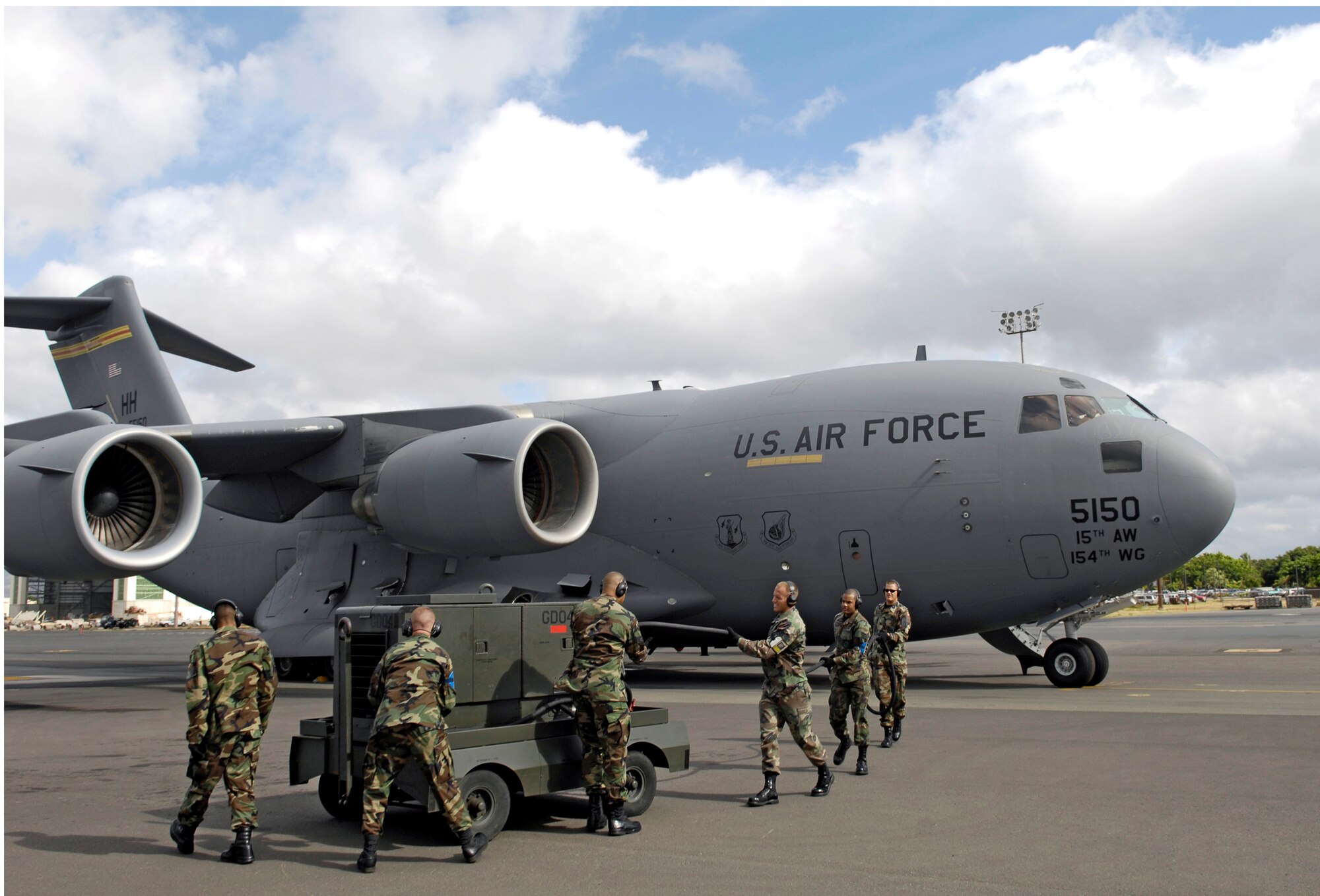Crew chiefs disconnect an auxiliary power unit from a C-17 Globemaster III June 28 before launching the aircraft from Hickam Air Force Base, Hawaii. The Airmen, from the 15th Aircraft Maintenance Squadron, are practicing for the upcoming Air Mobility Command Rodeo at McChord AFB, Wash. (U.S. Air Force photo/Tech. Sgt. Shane A. Cuomo)
