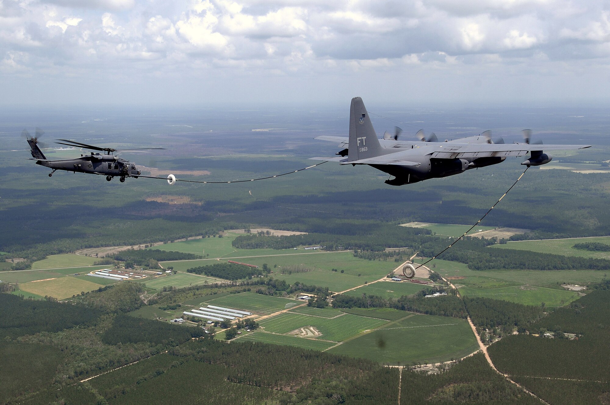 A HC-130P refuels an HH-60 Pave Hawk June 27 while being filmed by a video production team for the Air Force recruiting campaign, "Do Something Amazing."  The aircraft and crew are assigned to the 23rd Rescue Wing at Moody Air Force Base, Ga.  (U.S. Air Force photo/Master Sgt. Scott Reed) 