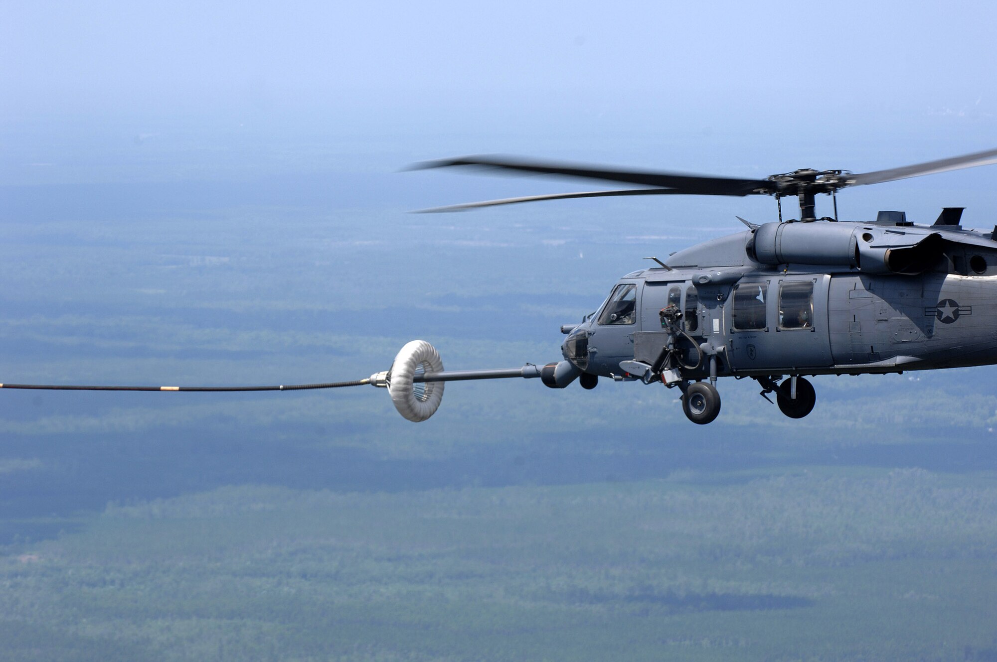 An HH-60 Pave Hawk is refueled June 27 while being filmed by a video production team for the Air Force recruiting campaign, "Do Something Amazing."  The aircraft and crew are assigned to the 41st Rescue Squadron at Moody Air Force Base, Ga.  (U.S. Air Force photo/Master Sgt. Scott Reed) 