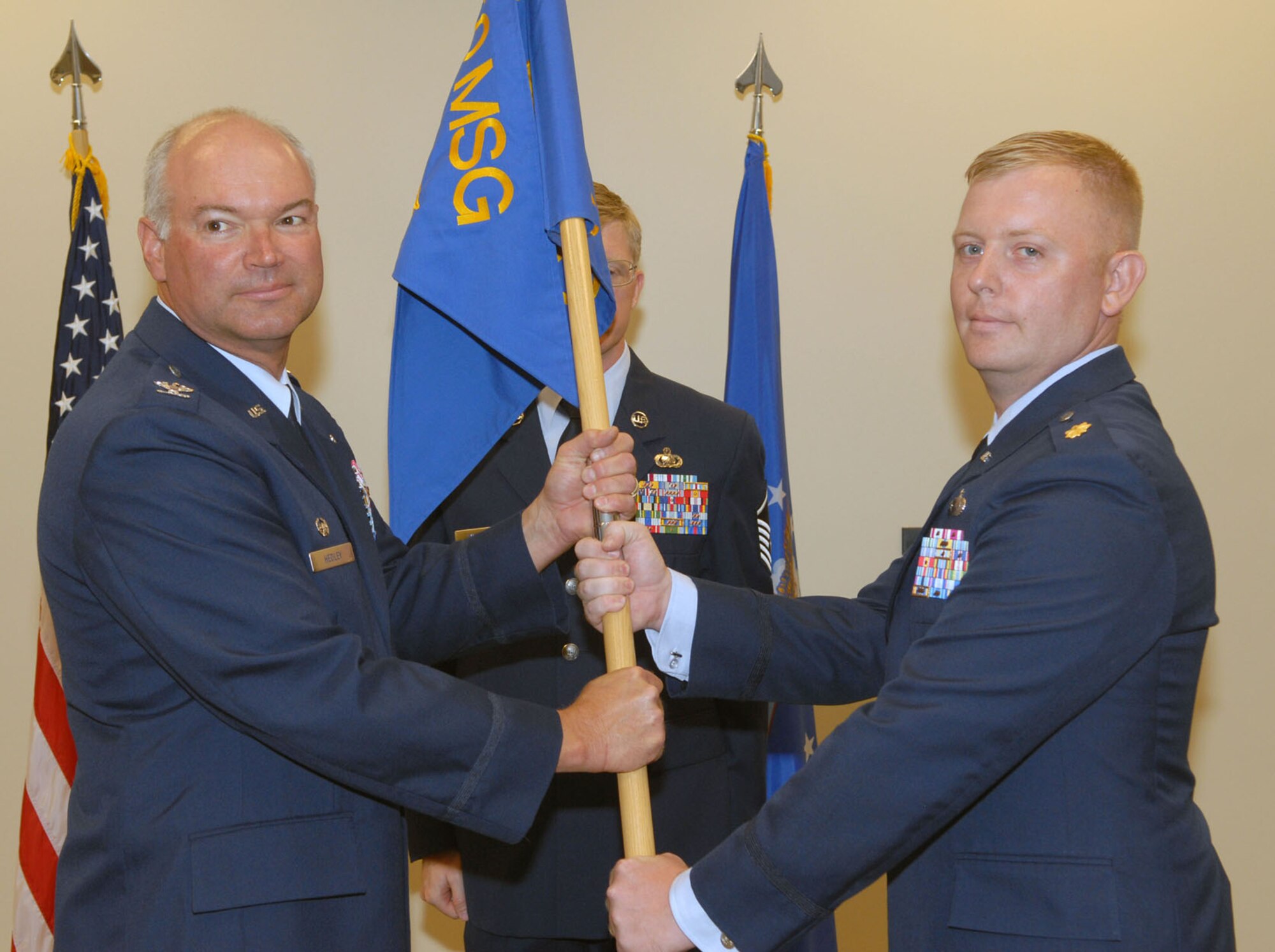 BUCKLEY AIR FORCE BASE, Colo. -- 460th Mission Support Group Commander Col. Bart Hedley hands the flag of the 460th Contracting Squadron to Maj. Paul Shaum to signify handing command of the squadron to him during a change of command ceremony July 5. (U.S. Air Force photo by Airman 1st Class Ladonnis Crump)