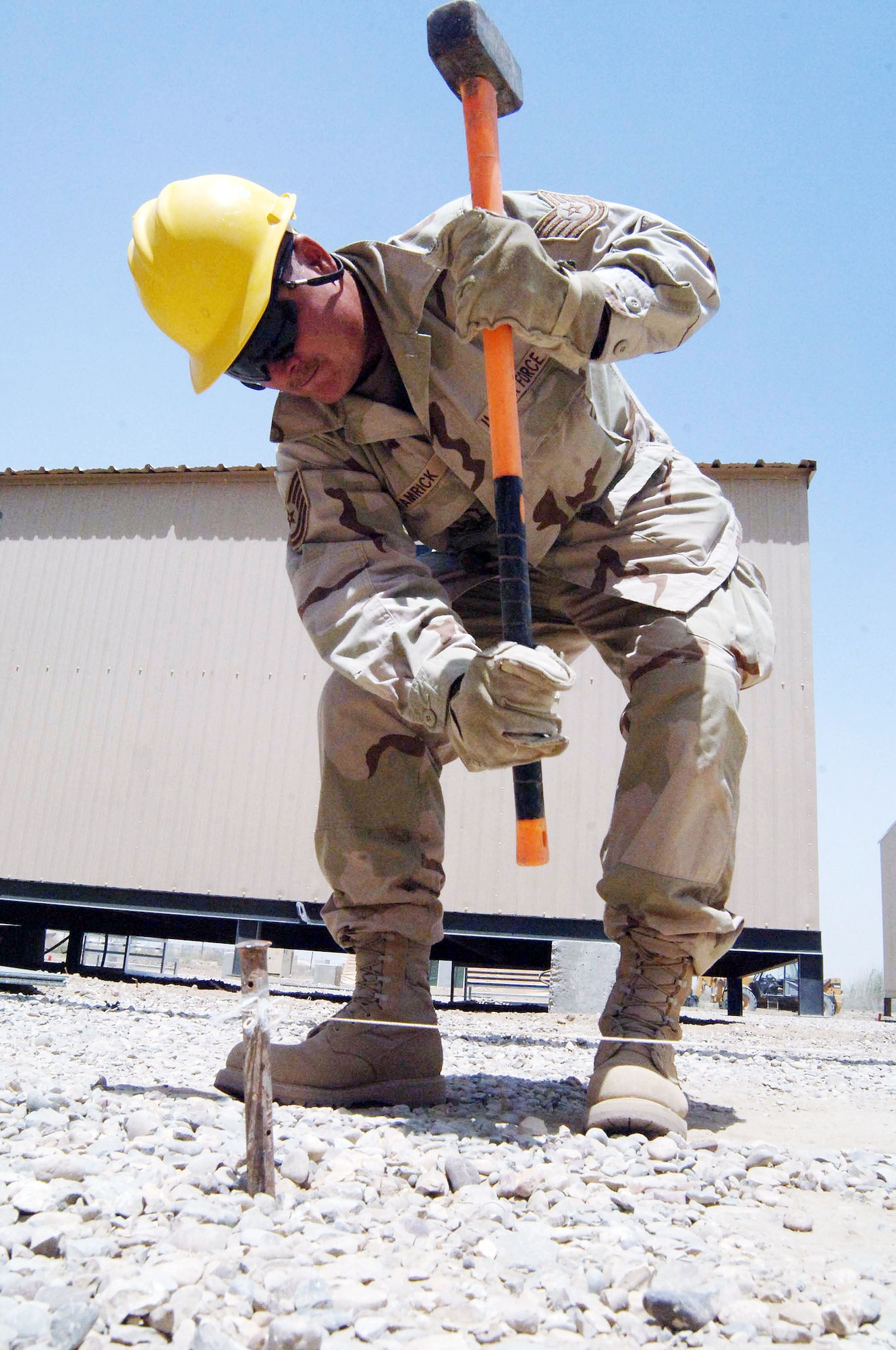 Tech. Sgt. Scott Hamrick pounds a stake in the ground used for lining up T barriers June 27 at Sather Air Base, Iraq. The barriers are part of a concrete wall being pieced together for protection against incoming rockets and mortars.  Sergeant Hamrick is a pavement specialist with the 447th Expeditionary Civil Engineer Squadron. (U.S. Air Force photo/Tech. Sgt. Russell Wicke)