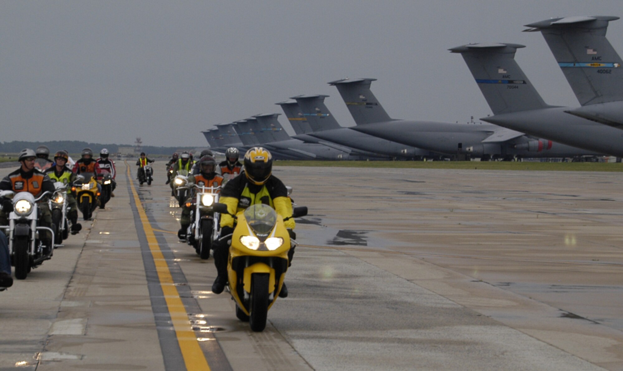 More than 30 Team Dover members roared by a line of Dover T-tails June 29 during the group ride down the flightline. (U.S. Air Force photo/Senior Airman James Bolinger)