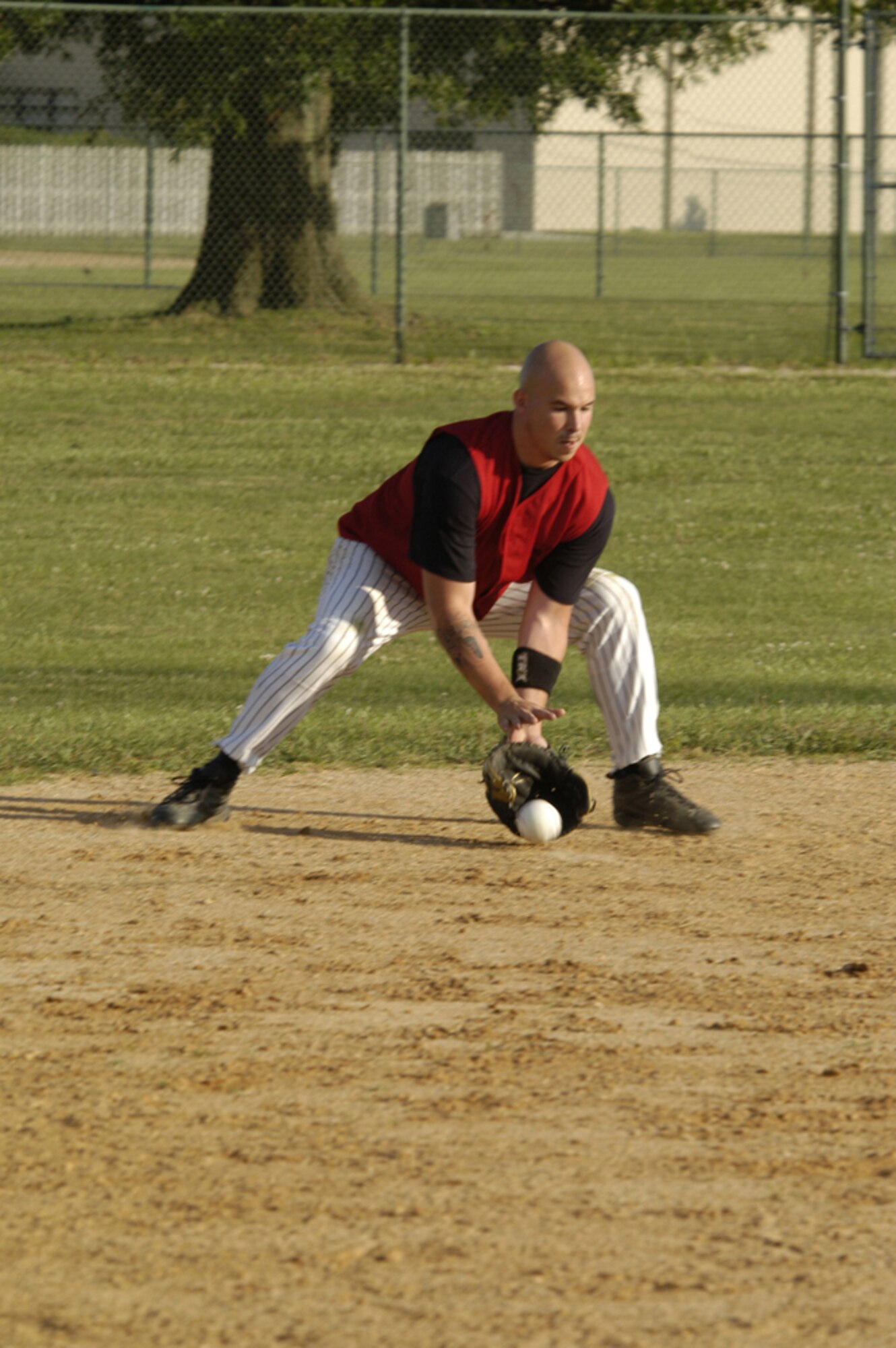 Preston Bolen, 436th APS short stop, scoops a grounder and launches it to first base for the out during Monday’s intramural softball game versus the 436th LRS. (U.S. Air Force photo/Senior Airman James Bolinger)