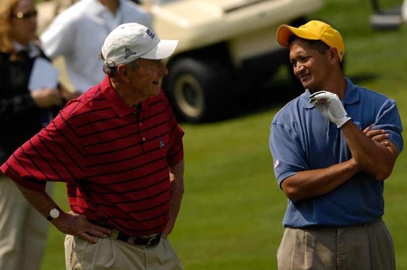 Tech. Sgt Andy Amor, 316th Civil Engineer Squadron, talks with former President George H.W. Bush durning a Pro-Am event. Pres. Bush joind Sergeant Amor for the last four holes at Congressional Country Club. Sergeant Amor was selected to represent the Air Force in the Pro-Am event before the start of the AT&T National Golf Tournament at Congressional Country Club in Bethesda, Md., July 4. Tiger Woods is the event host as well as a contestant and spokes person. (U.S. Air Force photo by Senior Airman Dan DeCook)
