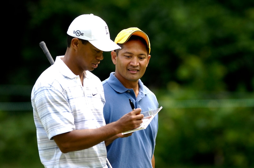 Tech. Sgt Andy Amor, 316th Civil Engineer Squadron, watches as professional golfer Tiger Woods signs an autograph during their round at a Pro-Am event. Sergeant Amor was selected to represent the Air Force in the Pro-Am event before the start of the AT&T National Golf Tournament at Congressional Country Club in Bethesda, Md., July 4. Tiger Woods is the event host as well as a contestant and spokes person. (U.S. Air Force photo by Senior Airman Dan DeCook)(Released)