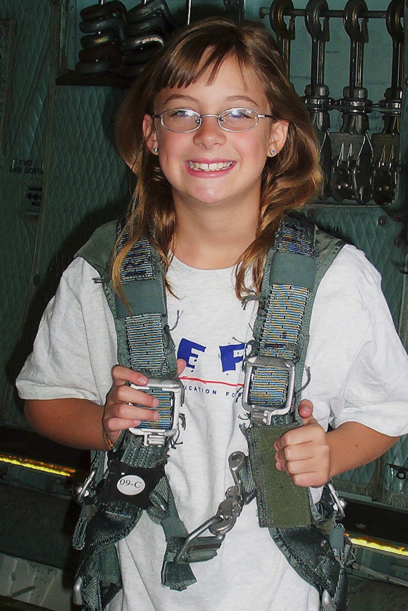 Madison Manske, 11, tries on a safety harness, during a C-5 flightline tour June 21. DEFY teaches drug refusal skills and healthy living habits through physical-fitness training. (U.S. Air Force photo/Sue Walls)