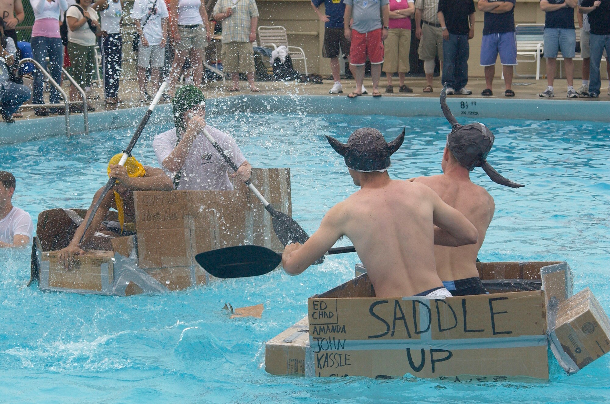 KUNSAN AIR BASE, Republic of Korea -- Senior Airman Peter Mellon and Army Staff Sgt. Thea Sm, American Forces Network-Kunsan (left) battle Airmen First Class Eddie Morell and Chad Hoing during the Fourth of July boat race here.  The base celebrated the U.S.'s 231st birthday.  Festivities included a watermelon-eating contest, float parade and fireworks show. Airmen Morell and Hoing are assigned to the 8th Maintenance Squadron. (U.S. Air Force photo/Staff Sgt. Darcie Ibidapo)