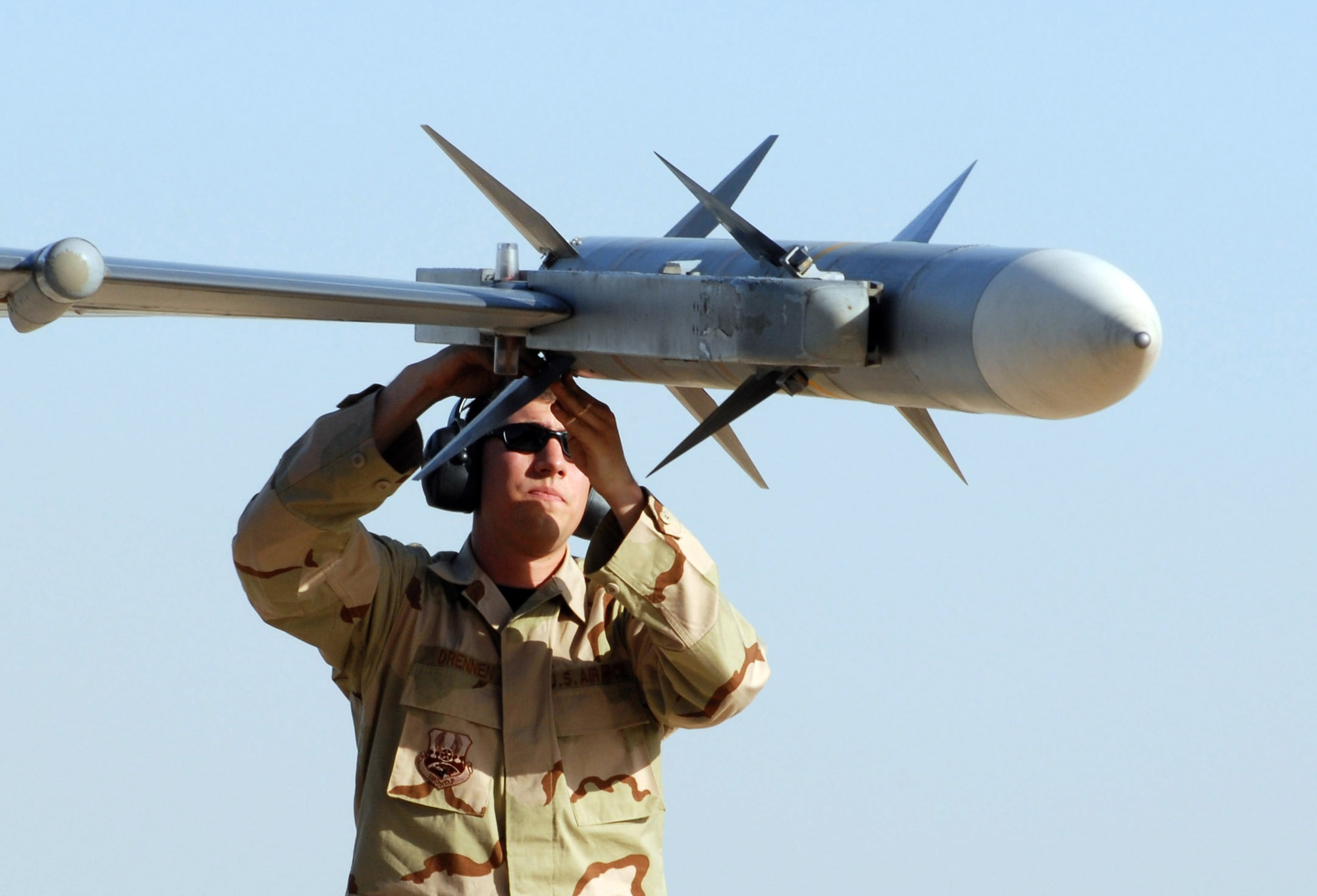 BALAD AIR BASE, Iraq -- Airman 1st Class Mark Drennen, a 332nd Expeditionary Aircraft Maintenance Squadron weapons load team member deployed from Misawa Air Base, Japan, checks the fins of an AIM-120 AMRAAM Missle on an F-16 Fighting Falcon before a combat mission here June 27. The 332nd Air Expeditionary Wing has three F-16 squadrons, consisting of active duty Airmen, Air National Guardsmen and Air Force Reservists. The wing's F-16s are currently playing key close air support and show of force roles in Baqoubah for Operation Arrowhead Ripper. (photo by 1st Lt. Shannon Collins) 