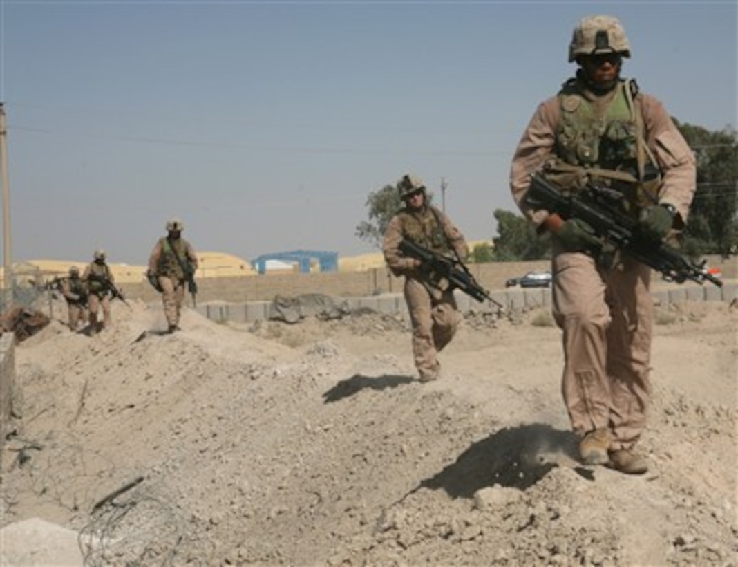 U.S. Marine Corps Lance Cpl. James K. Williamson (right) and his unit return to base at the end of a security patrol in Karmah, Iraq, on June 22, 2007.  The Marines are assigned to 1st Squad, 2nd Platoon, Kilo Company, 3rd Battalion, 6th Marine Regiment.  