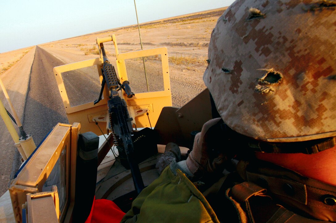 AL TAQADDUM, Iraq (July 7, 2007) ?  A gunner provides rear security for a security patrol here. As the insurgents try to thwart Iraq?s progress, it is the responsibility of the Marines with Military Police Company, 2nd Maintenance Battalion, 2nd Marine Logistics Group (Forward) to keep a watchful eye on the roads. At the ?tip of the spear? of the patrols are the patrol leaders mostly of whom are corporals: the junior noncommissioned officer rank in the Corps.