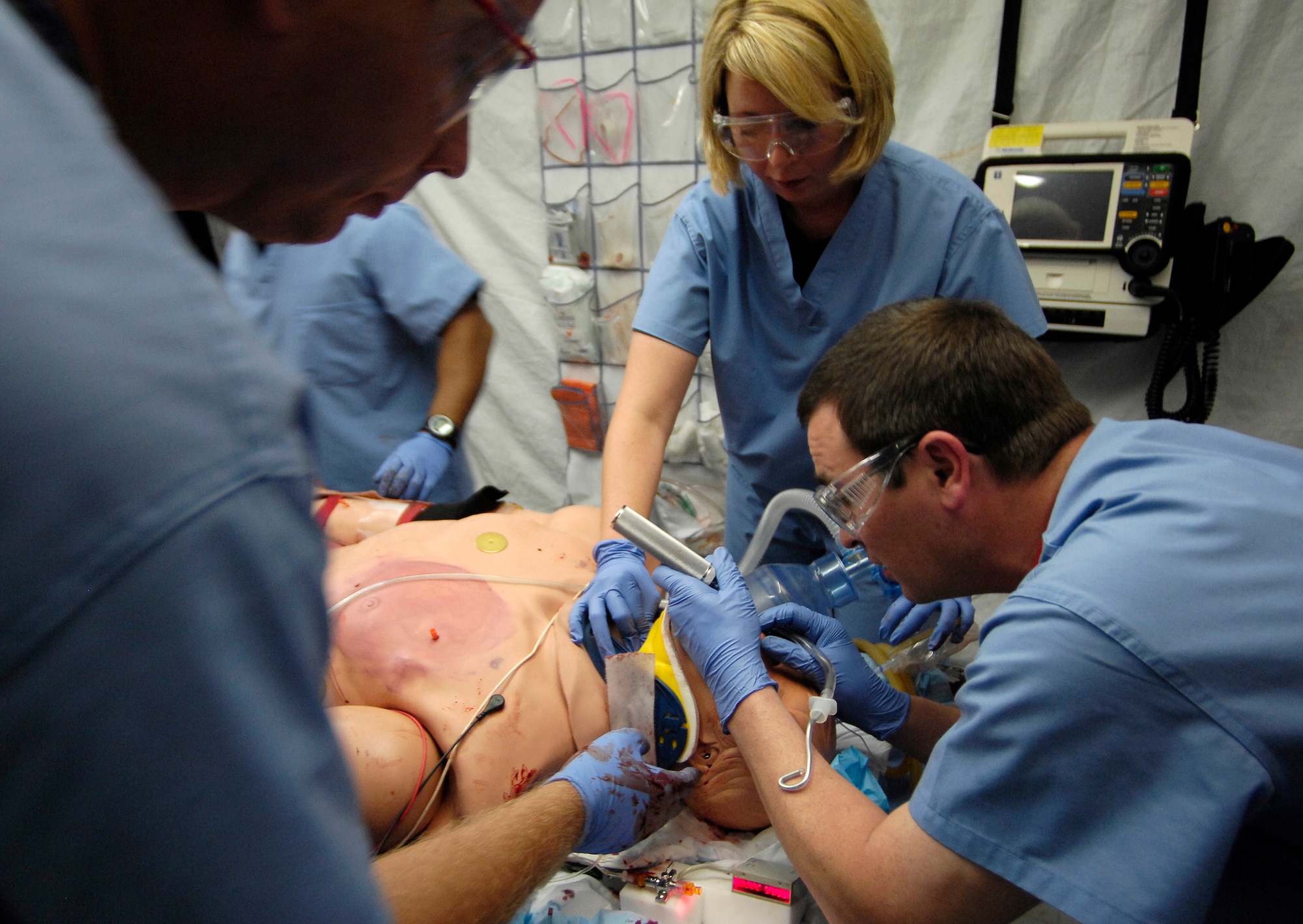 Capt. Jeremy Egly, Staff Sgt. Rebecca Timms and Maj. David Olson (left to right) work on a human patient simulator July 5 during a training scenario at the St. Louis University Hospital.  The Center for Sustainment of Trauma and Readiness Skills, or C-STARS, is a training program created for Air Force medical personnel that is integrated into major civilian trauma centers throughout the continental United States. Training with civilian counterparts provides real-life hands on trauma care experience for Air Force medical personnel. (U.S. Air Force photo/Staff Sgt. Brian Ferguson) 