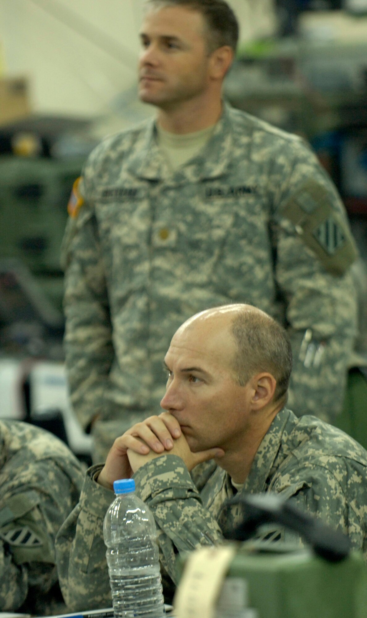 U.S. Army Col. James Adams, deputy commander of the 2nd Brigade combat team, and his staff watch real-time surveillance video June 25 at Forward Operating Base Kalsu, Iraq, during a bombing mission to destroy a suspected explosives-laden roadway south of Baghdad.  Air Force joint terminal attack controllers working with Colonel Adams' staff called in a B-1 Lancer to bomb the suspected main supply route used by insurgents to bring accelerants from the south into the Baghdad area.  The controllers are with the 15th Expeditionary Air Support Operations Squadron and are assigned to provide support to the U.S. Army's 2nd Brigade combat team, 3rd Infantry Division. (U.S. Air Force photo/Master Sgt. Jim Varhegyi