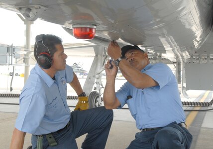 Manuel Arevalo, 12th Maintenance Division crew chief and aircraft mechanic, reinstalls a fastner on a T-38C while fellow crew chief Robert Reyna watches, ready to help. (U.S. Air Force photo by Rich McFadden)