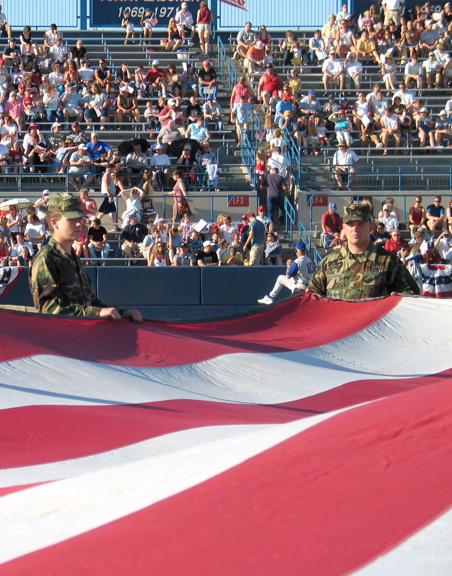 FAIRCHILD AIR FORCE BASE, Wash. – Airman 1st Class Jonathan Luzader (left), 92nd Aircraft Maintenance Squadron aerospace maintenance apprentice, and Master Sgt. Wade Claussen, 92nd Maintenance Operations Squadron training flight chief, hold an American flag on the Avista Stadium baseball field in Spokane during a patriotic pre-game ceremony July 4. Thirty active-duty members from Fairchild participated in the flag unfolding at the Spokane Indians vs. Vancouver Canadians game, and the Fairchild Honor Guard posted the colors during the singing of the National Anthem. More than 7,000 people attended the game. (U.S. Air Force photo/ Staff Sgt. Connie L. Bias) 