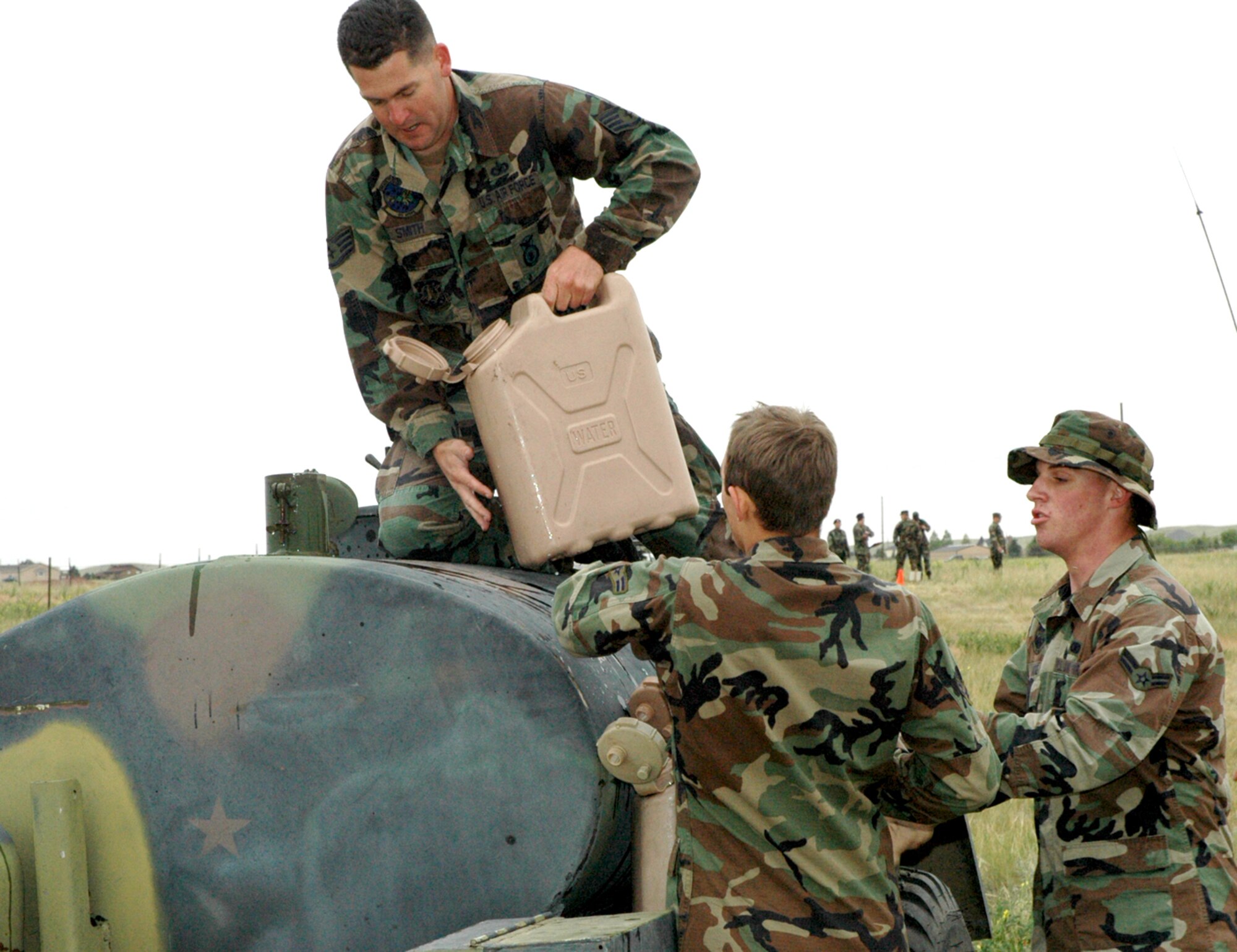 Staff Sgt. Eric Smith, 90th Missile Security Forces Squadron, empties the last 40-pound jug of water into the water buffalo in the water re-supply event. The Airmen had to fill up the jugs and run over to a supply container and top it off with water (Photo by Airman 1st Class Daryl Knee).

