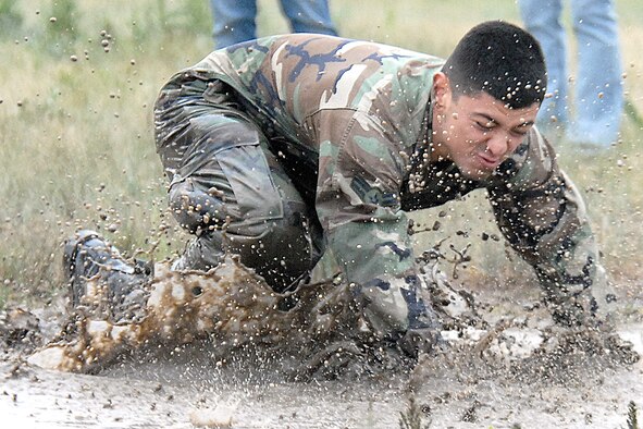 Airman 1st Class Wesley Arrambide, 90th Missile Security Forces Squadron flight 3, takes a dive into a muddy puddle during the ‘Team Pain’ portion of this year’s Crow Creek Challenge June 27. Members of the 90th Security Forces Group competed in 14 different stations this year in hopes of becoming the best squadron over all (Photo by Shelly Raffl).
