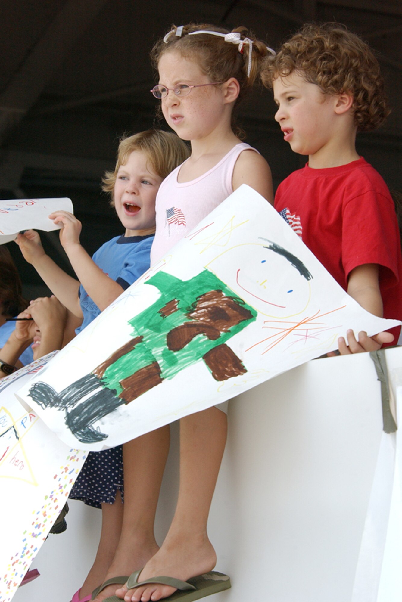 Welcome home signs, like these waved proudly by children eagerly anticipating the return of their parents, added an extra touch of emotion to the patriotic homecoming at Hurlburt Field, Fla., July 4. More than 200 Airmen returned home to their families after deployments to Iraq and Afghanistan. (U.S. Air Force photo/Tech. Sgt. Angela Shepherd)