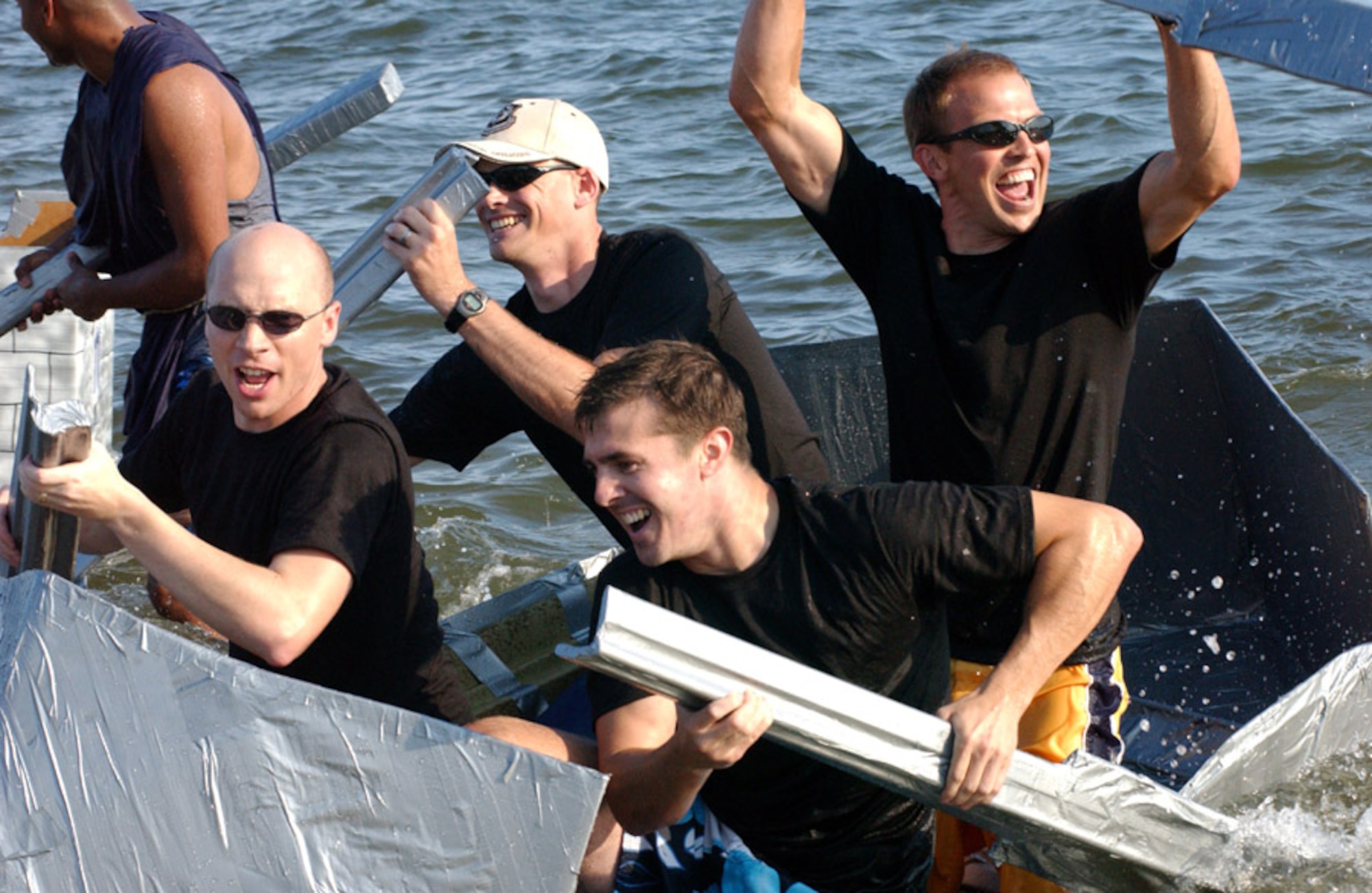 The crew of the USS David Hasselhoff, from the 1st Special Operations Wing staff judge advocate office, celebrate their victory as they make it back to shore first during the Cardboard Boat Regatta during Hurlburt's 29th Annual Sound of Independence at the marina June 29.  (U.S. Air Force photo/Tech. Sgt. Angela Shepherd)
