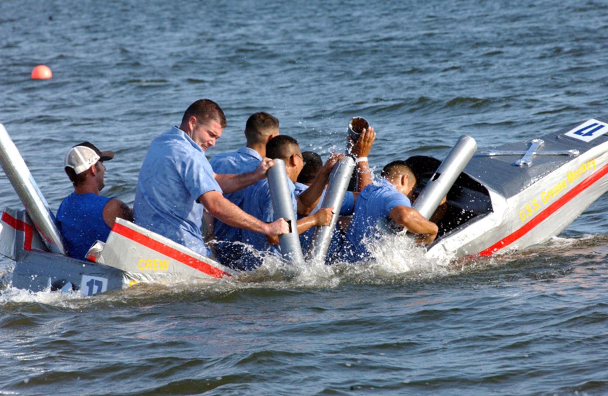 The crew of the SS Grease Monkey, from the 1st Special Operations Logistics Readiness Squadron, paddles furiously during the Carboard Boat Regatta at Hurlburt's 29th Annual Sound of Independence at the marina June 29. They won the award for the most unique boat. (U.S. Air Force photo/Tech. Sgt. Angela Shepherd)
