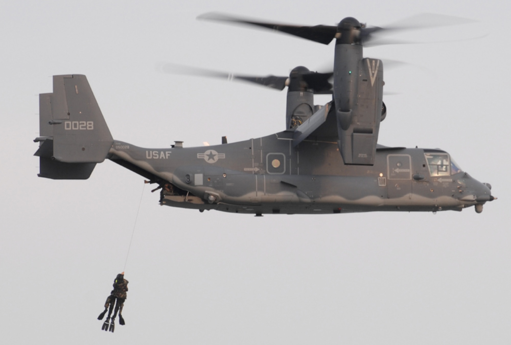 An 8th Special Operations Squadron Airman hoists a Navy SEAL up into a CV-22 Osprey. The 8th SOS worked with the SEALs on maritime operations at Lake Jackson in Florala, Ala., June 27-28. (U.S. Air Force photo/Senior Airman Andy Kin)