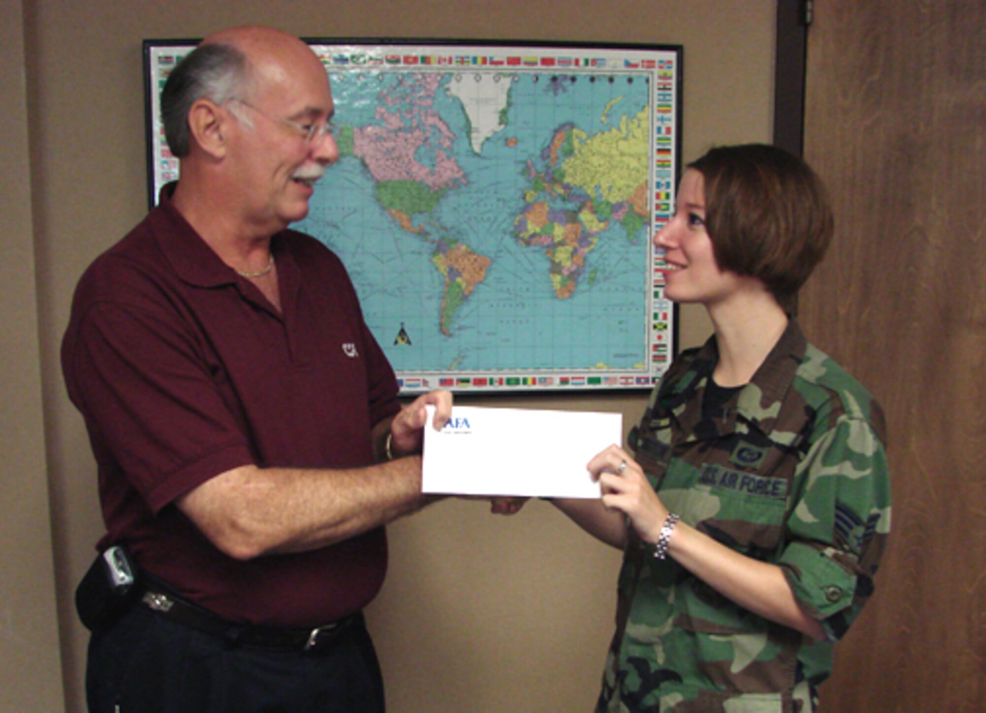 James Jacobs, Air Force Association Enid chapter president, presents a $50 check to Senior Airman Nicole Harrington, 71st Operations Support Squadron weather flight, after her return from a deployment to Iraq. Enid AFA Chapter 214 thanks all returning E-4s and below with a check. (US Air Force photo/Frank McIntyre)