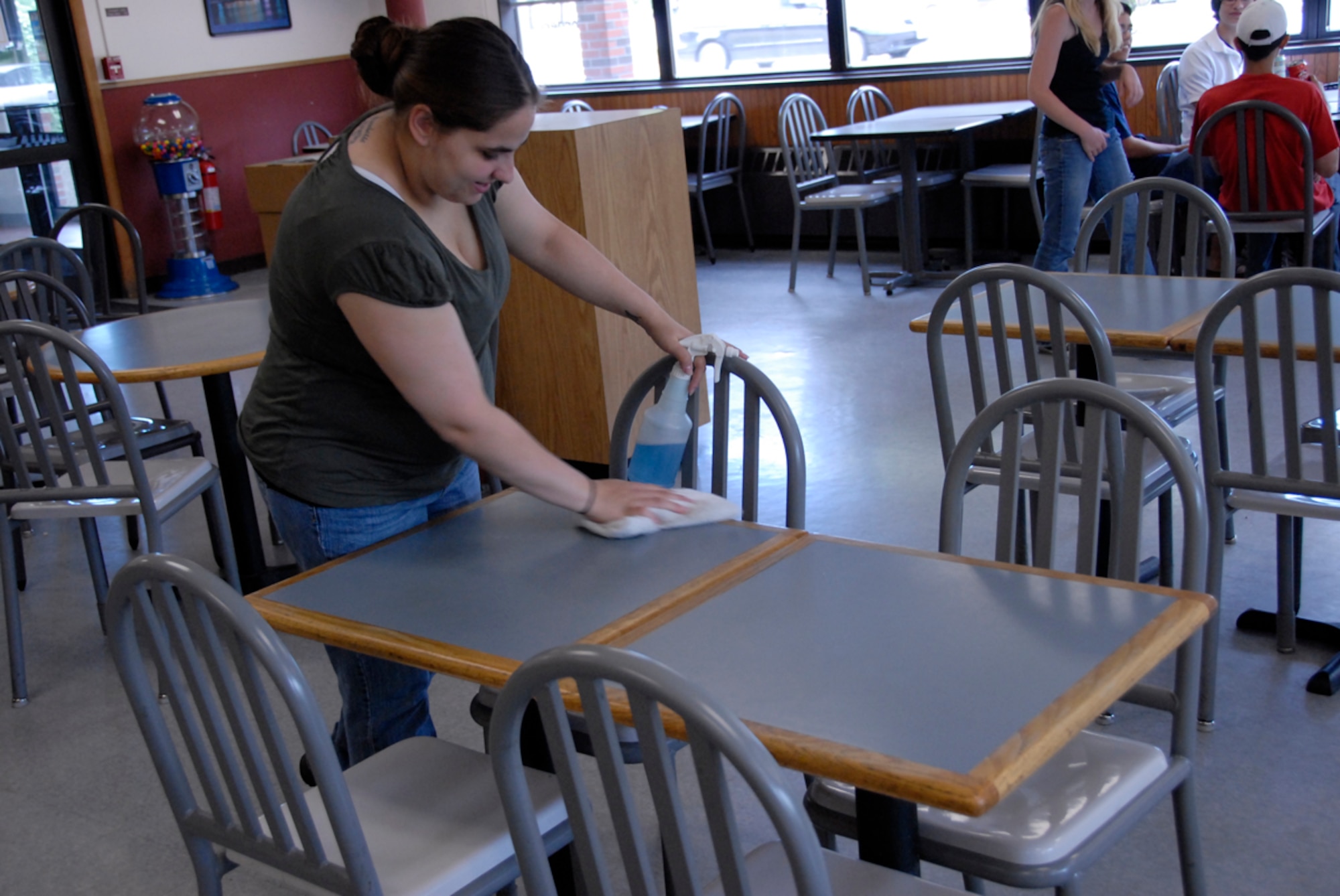 Hanscom AFB -- A&P Pizza Cashier Nicole Morse cleans tables at the establishment, which is located next to the Shoppette, June 29. Mrs. Morse used the Heimlich Maneuver on a patron who was choking June 27. (U.S. Air Force photo by Senior Airman Clinton Atkins)