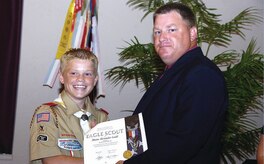Master Sgt. Stephen B. Ladd congratulates his son, Shaun, for achieving the rank of Eagle Scout.  Shaun earned a total of 27 merit badges over a four-year period, and built  a relocatable guard house for the 316th Security Forces Squadron as part of a community service project for his final task to earn Eagle Scout.  Master Sgt. Ladd is assigned to the 316th Logistics Readiness Squadron Vehicle Operations Flight as equipment support supervisor. (Photo by Bobby Jones)
